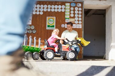 Kind fährt mit Trettraktor | © Urlaub am Bauernhof / Alexander Kaiser